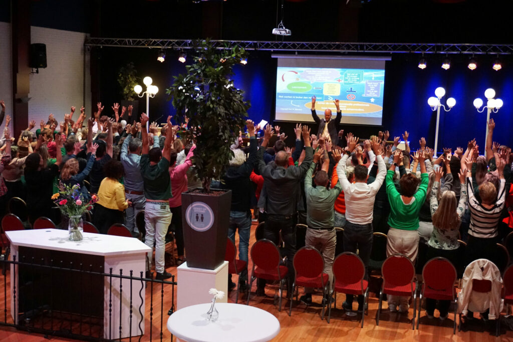 Publiek bij jubileum SWVO met handen in de lucht